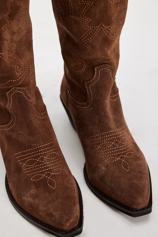 Brown suede cowboy boots with decorative stitching on a white background