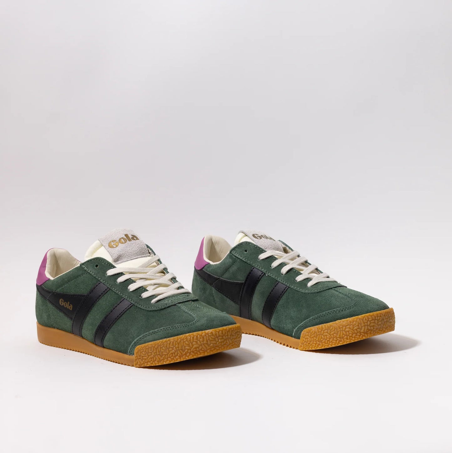 classic green suede Gola sneakers with black stripes, white laces, gum sole, and purple heel tab.