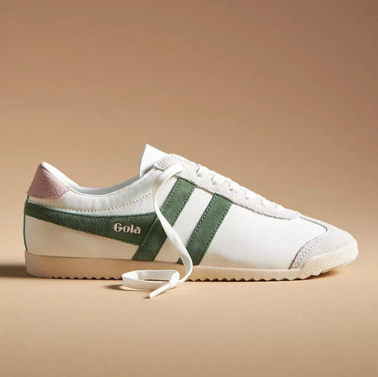 Pair of Gola Pure Sneaker Evergreen in white leather with green suede side stripes, featuring a retro-inspired design and lace-up closure on a beige background