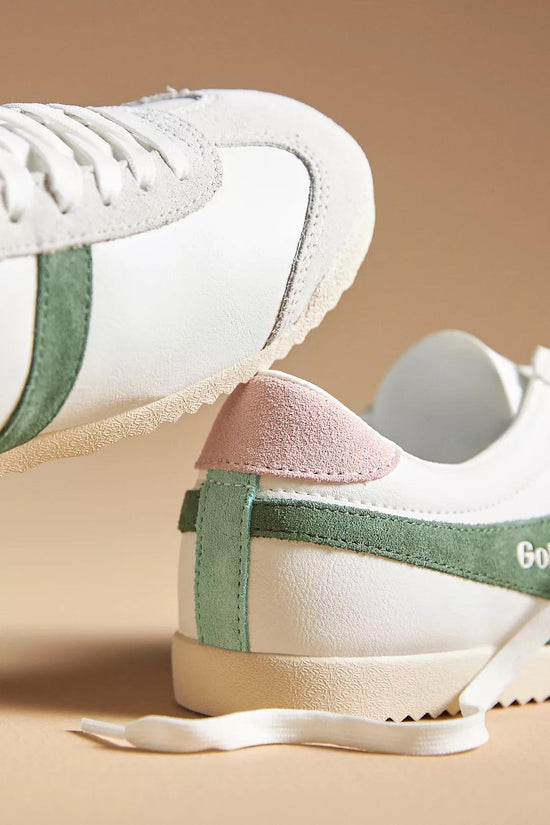 Pair of Gola Pure Sneaker Evergreen in white leather with green suede side stripes, featuring a retro-inspired design and lace-up closure on a beige background