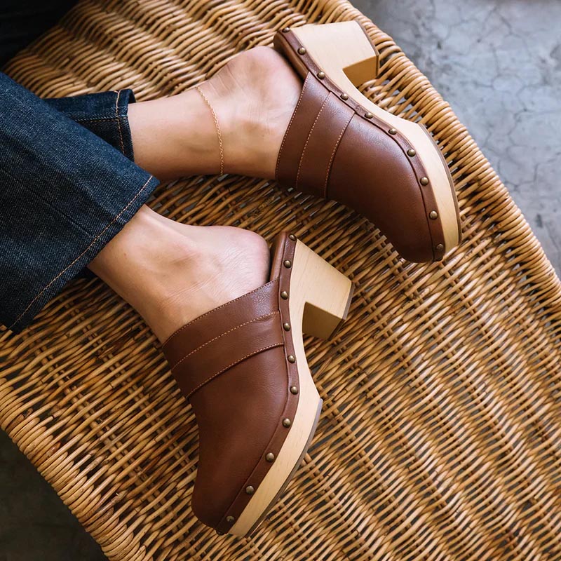 a brown wooden platform clog with a studded detail along  the side of the entire clog made by beach by Matisse Footwear