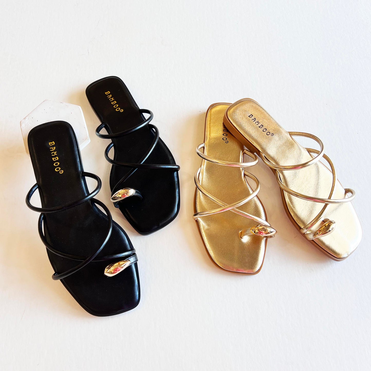 Pair of black strappy toe ring sandals for women, featuring sleek straps and a stylish toe ring."