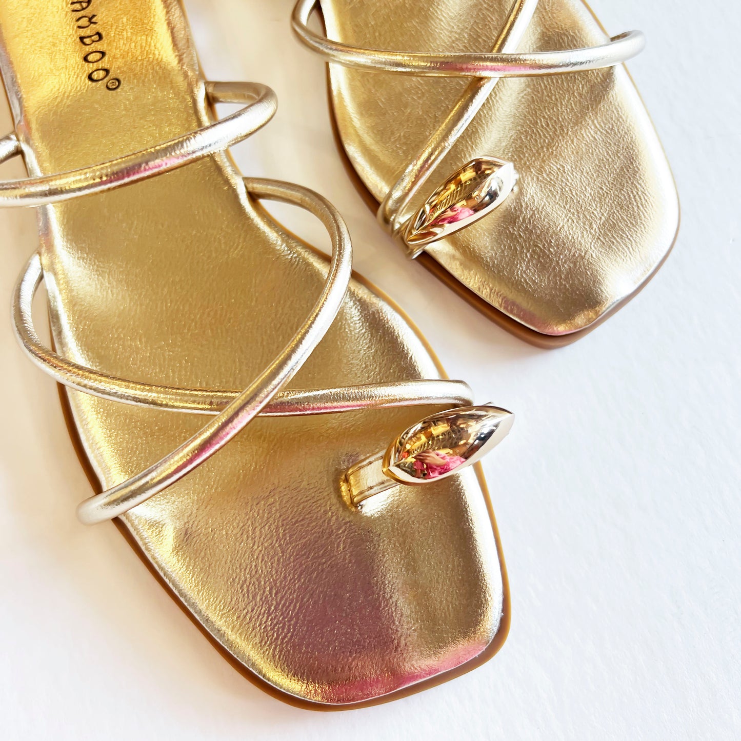 top view and up close of a Pair of gold strappy toe ring sandals for women, showcasing metallic straps and a chic toe ring.